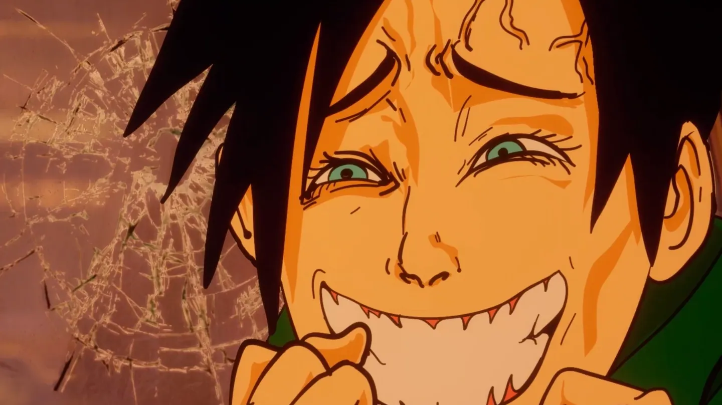 Close-up of a dark-haired person grinning wildly, showing sharp teeth, with cracked glass behind them.